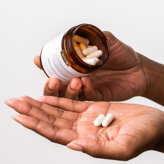 NMN + Resveratrol bottle and capsules in hand